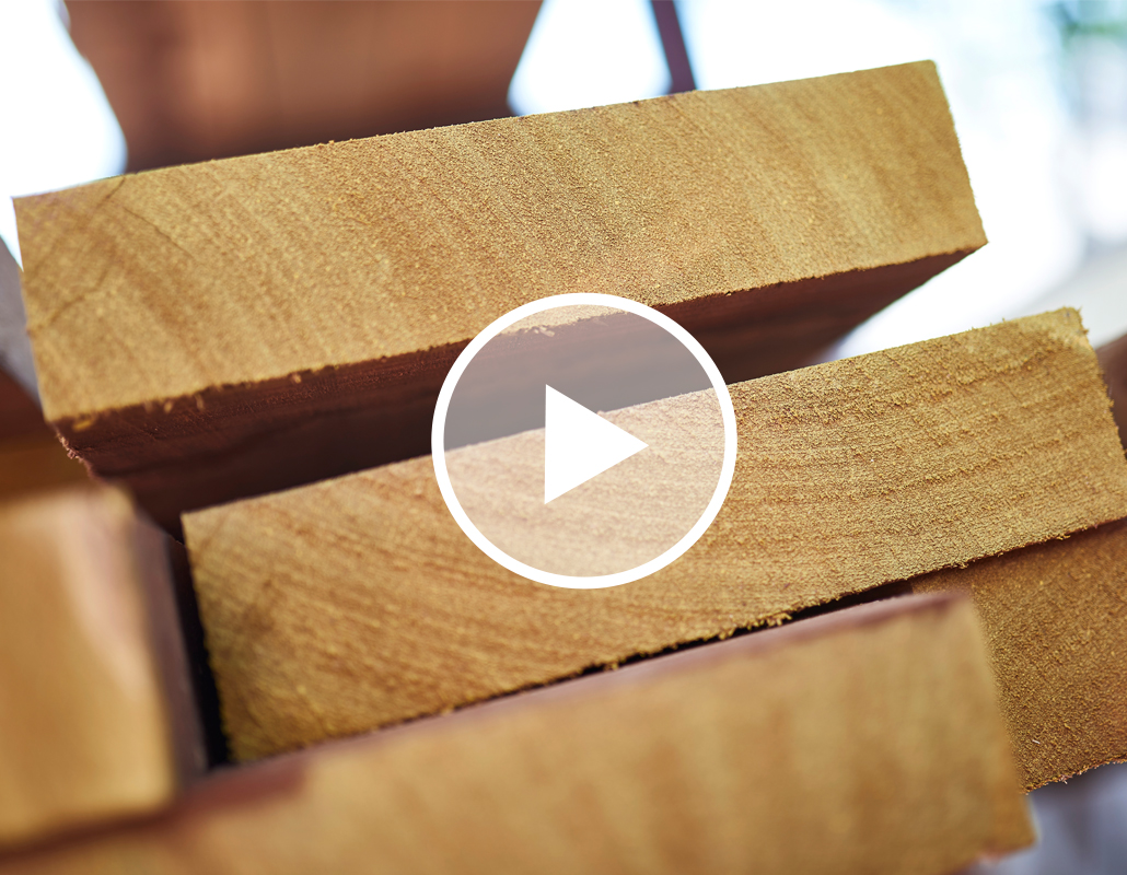 Close-up of stacked wooden planks with a play button icon overlay.