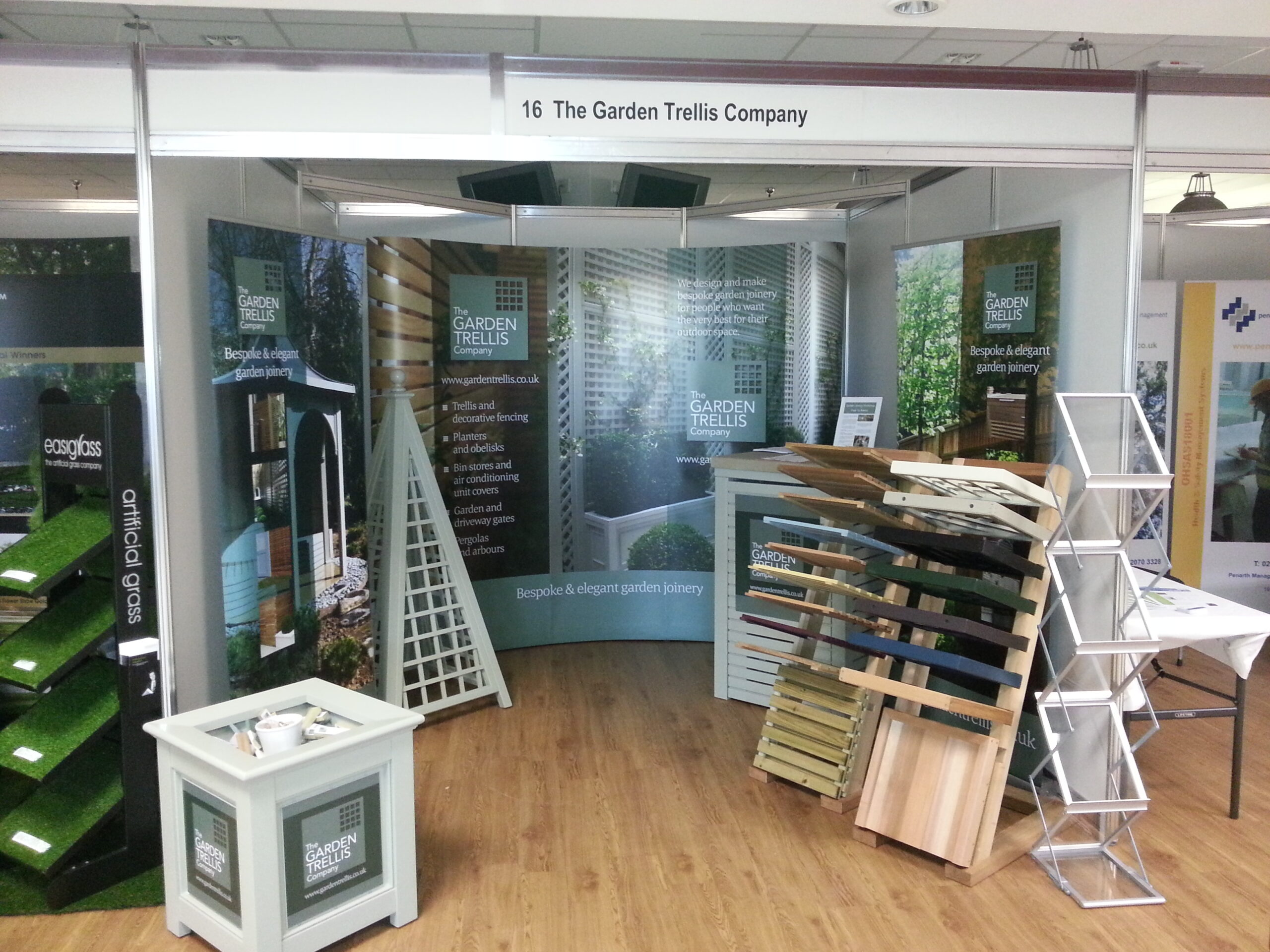 Trade show booth for The Garden Trellis Company displaying garden trellises and fencing panels.