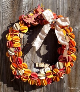 A colorful fall wreath with orange and yellow elements, a ribbon bow, and trick or treat letters.