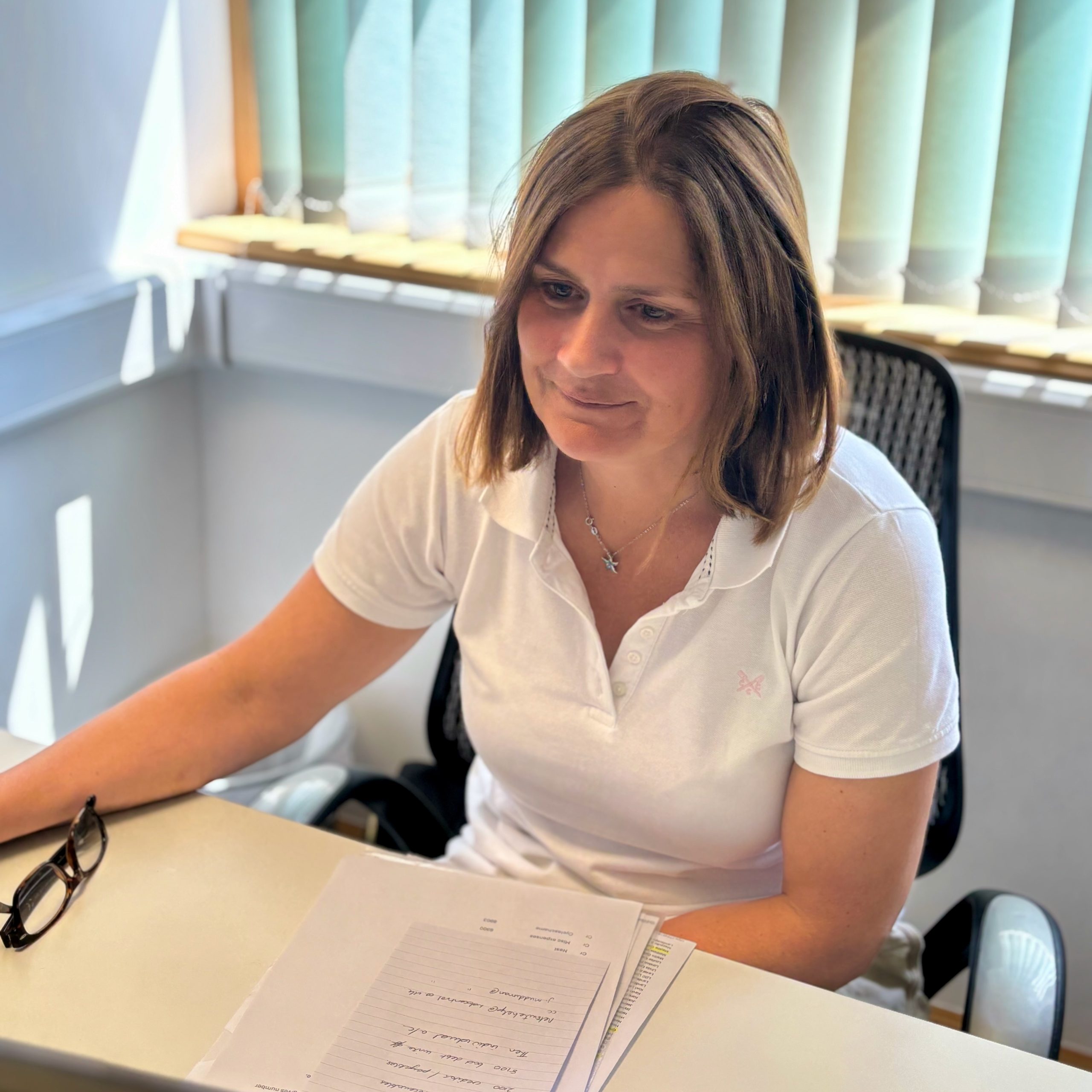 A lady in a white t-shirt working in an office