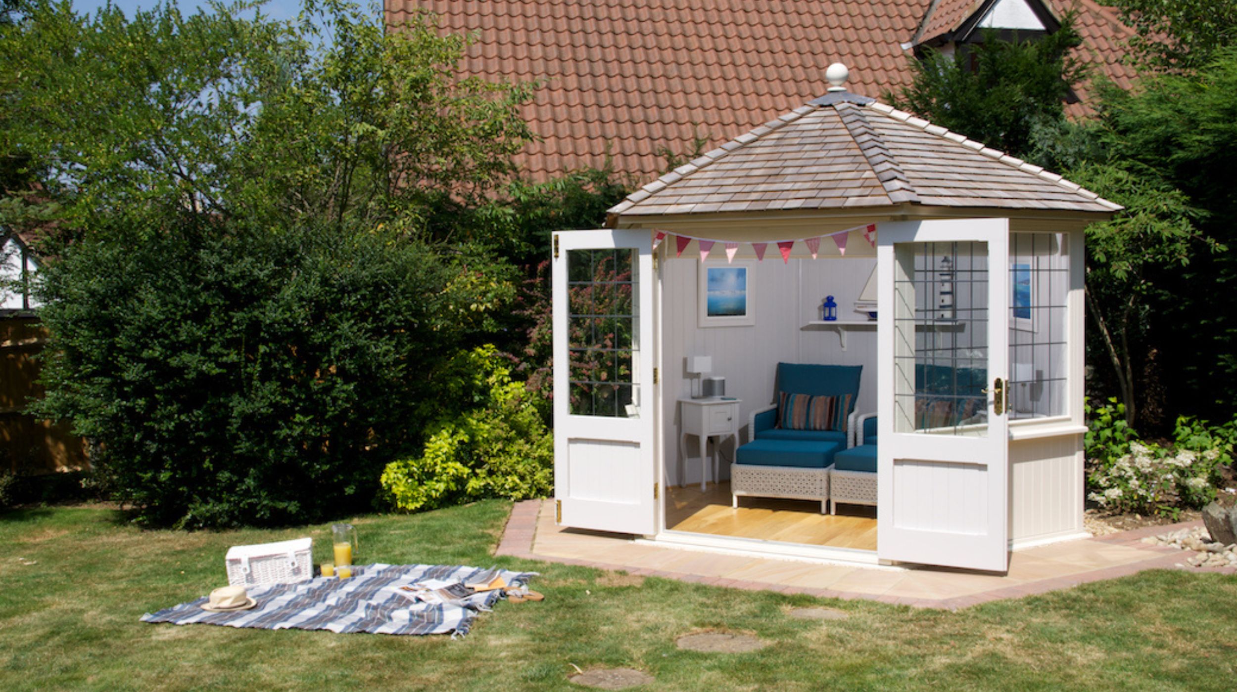 Bespoke summer garden room with coastal styling and a picnic outside.