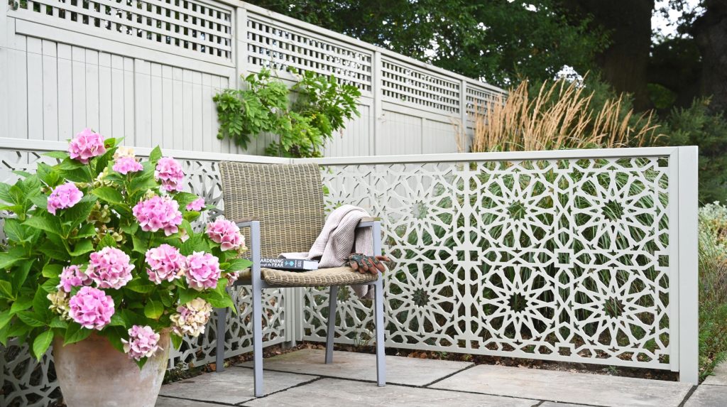 The Medina Decorative Screen painted in Manhattan Grey creating a relaxing zone in a garden.