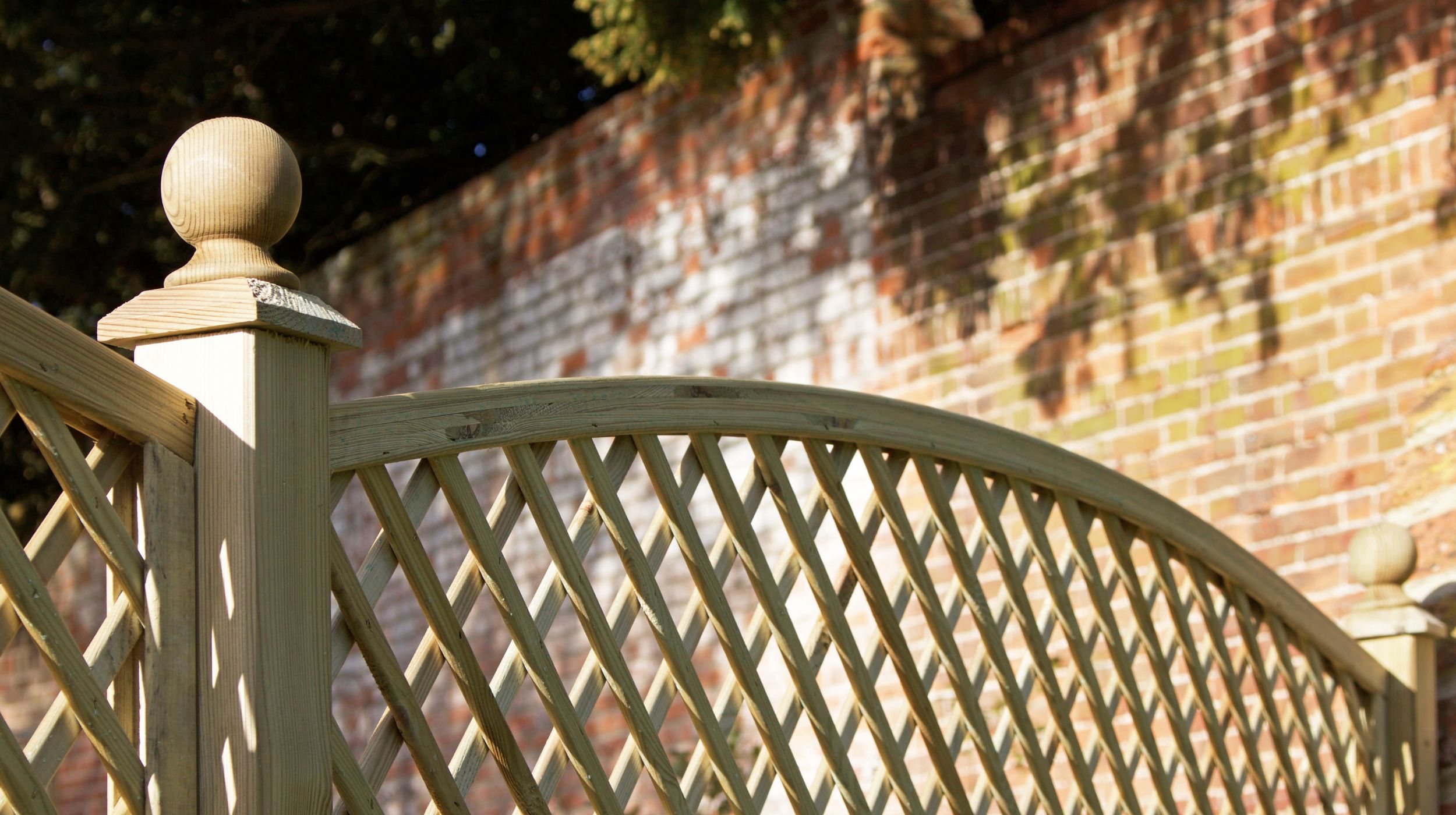 Diagonal Arch Top Trellis Banner and Blog image Diagonal Arch Top Trellis next to a high brick wall.